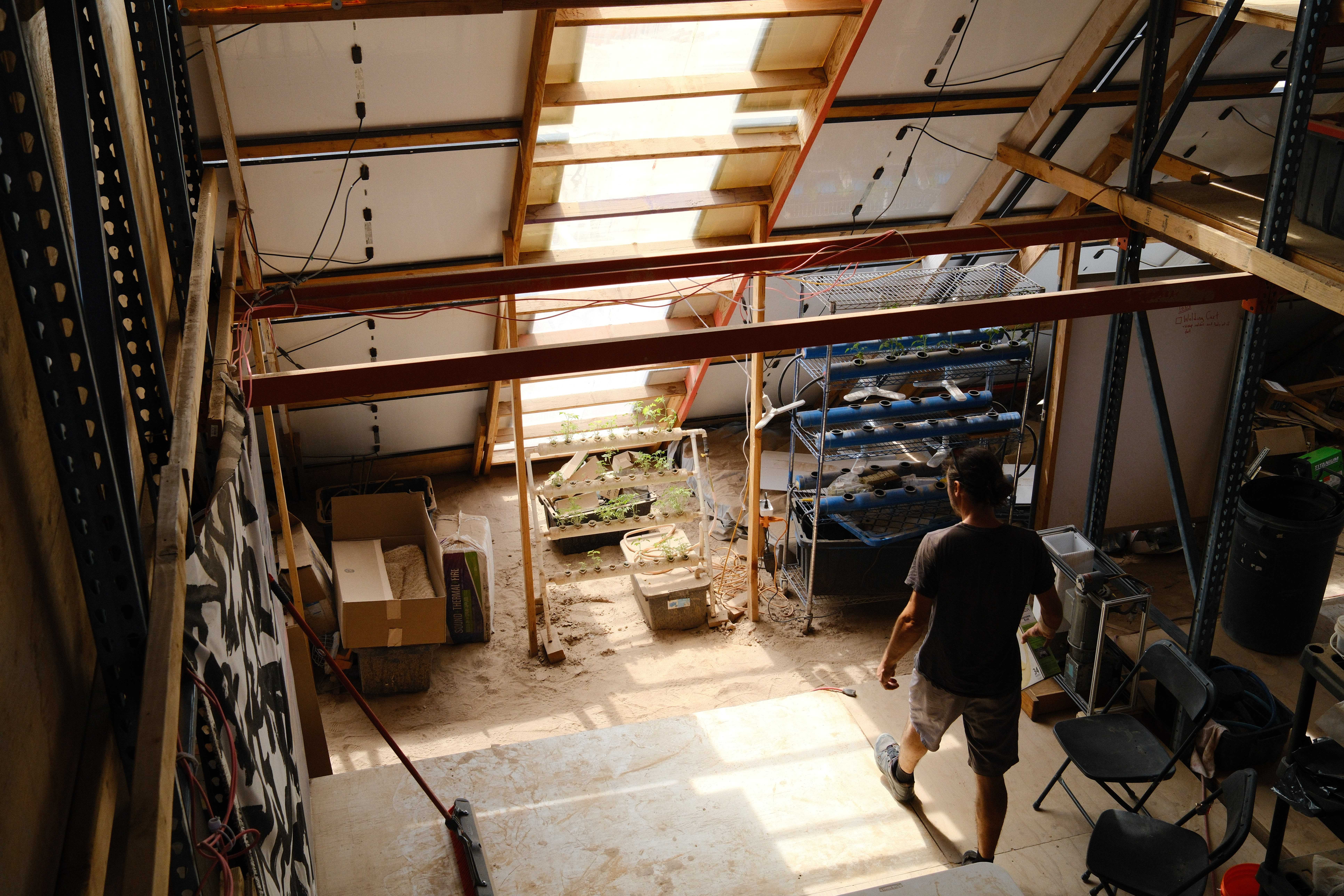 An overhead view inside a workshop showing hydroponic systems and other builds.