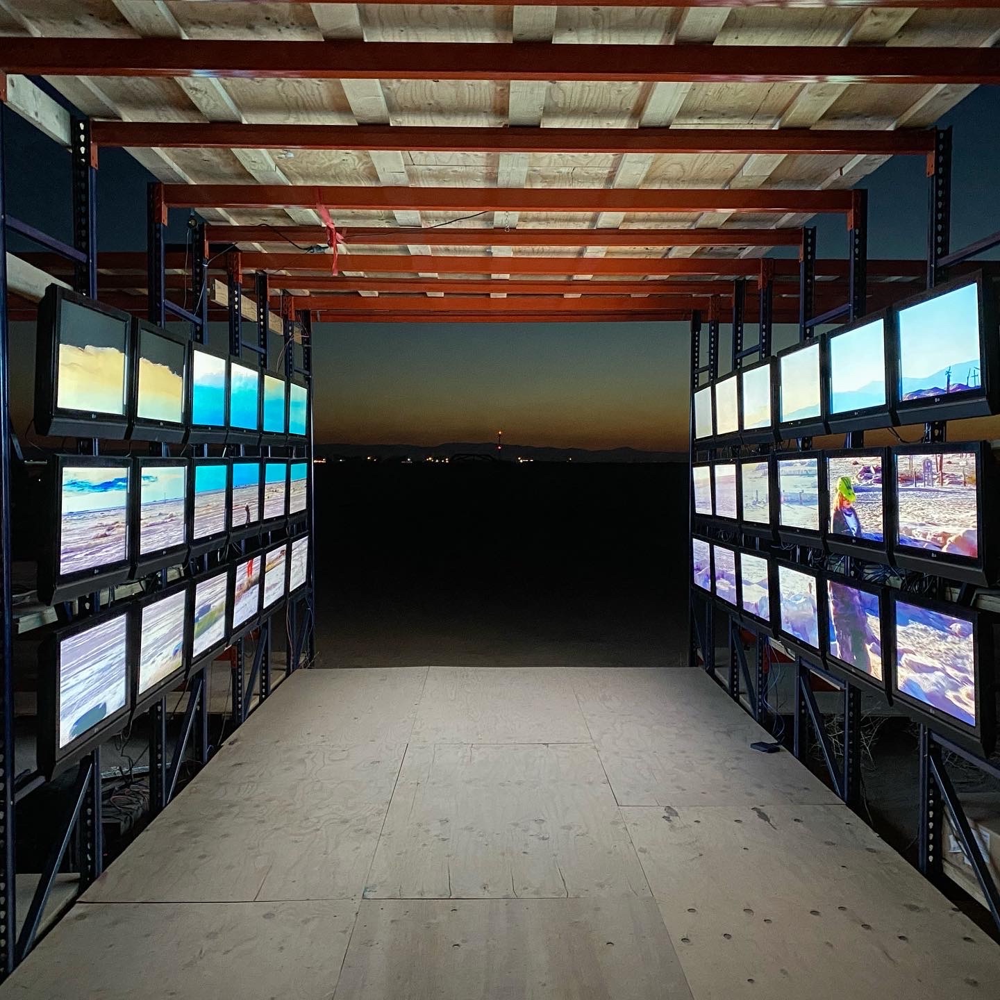 An art installation of CRT monitors in a long corridor facing the desert.