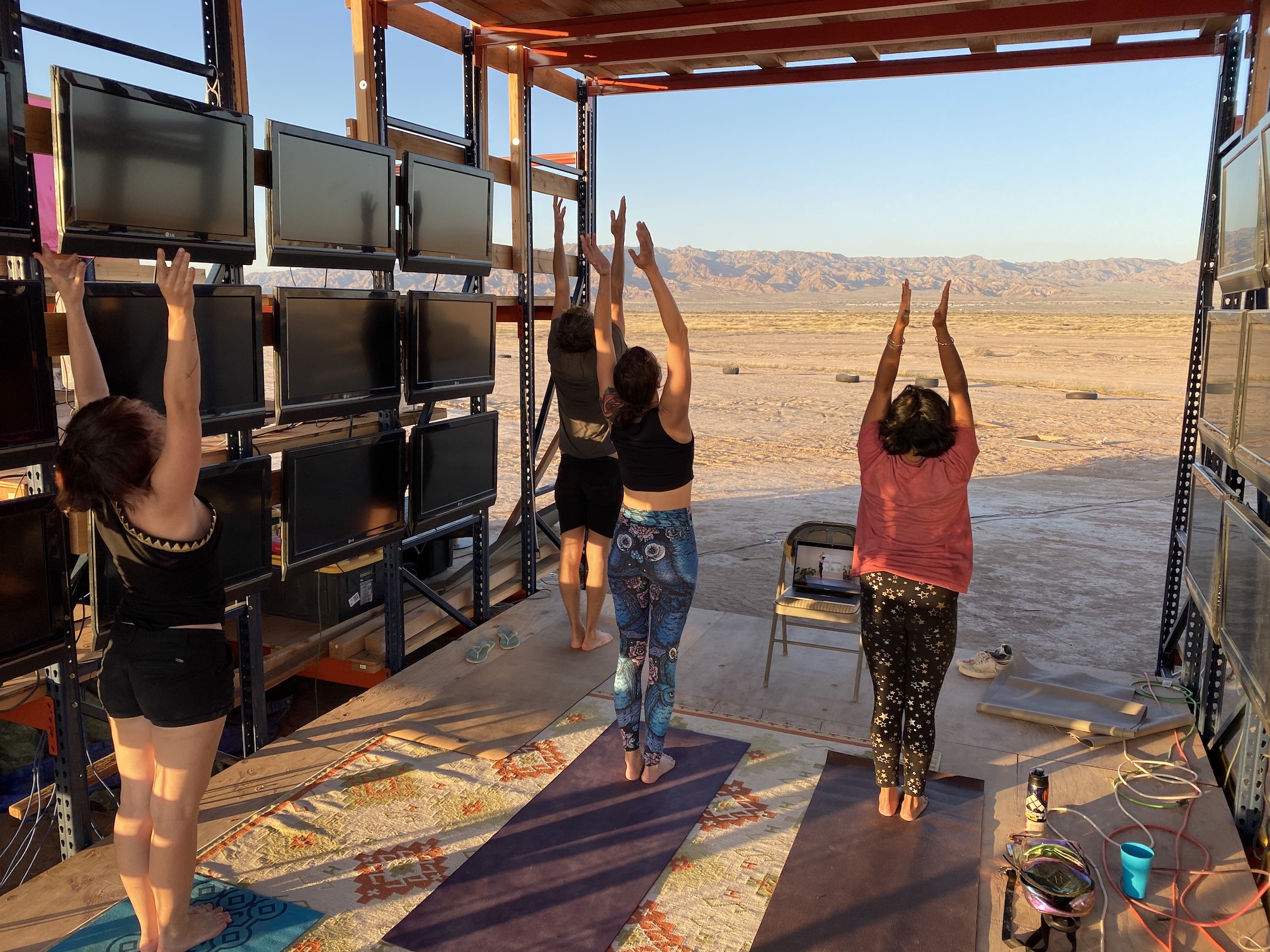 A group doing yoga at sunrise in the desert.